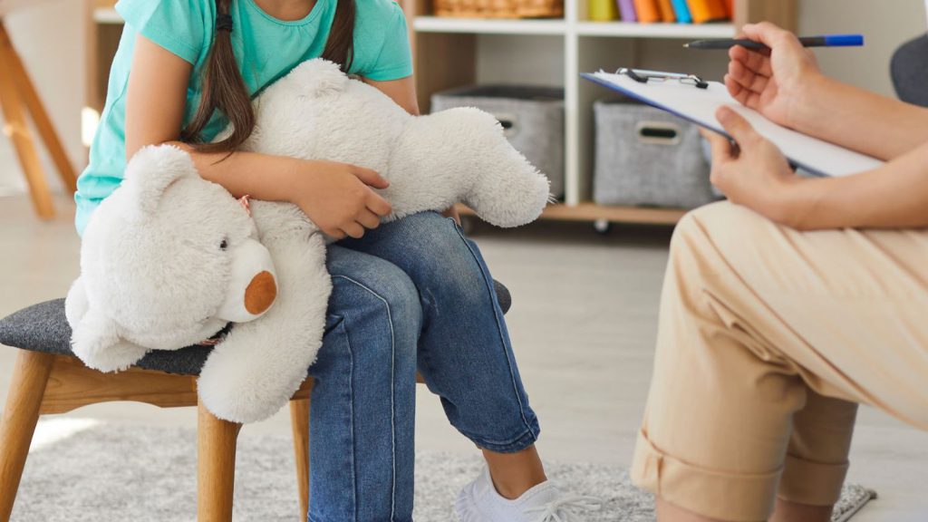 image of student holding teddy bear during a counseling session