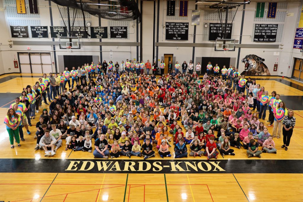 A group photo of hundreds of students and faculty in a gymnaisum