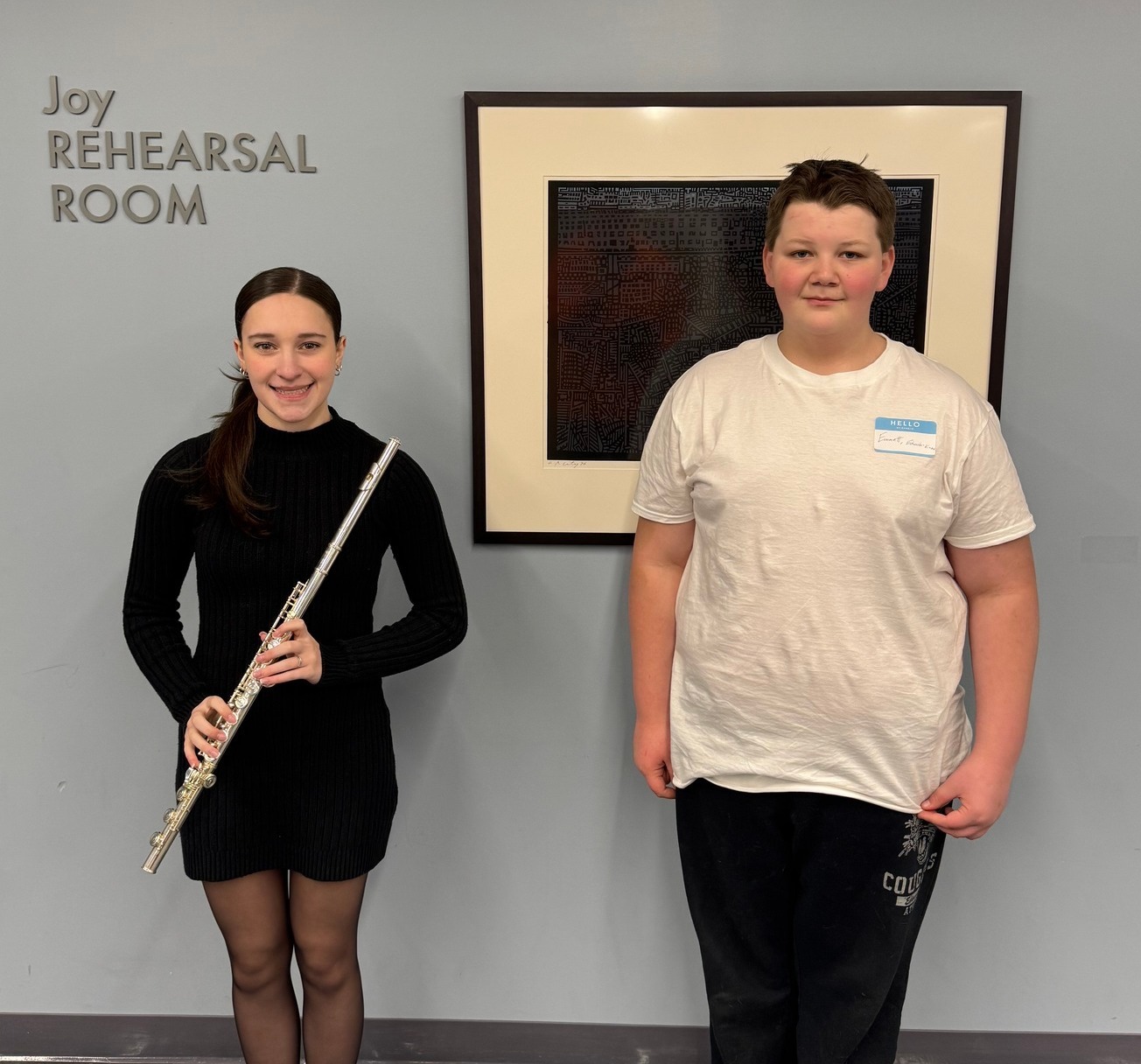 Female student holding a musical instrument and a male student