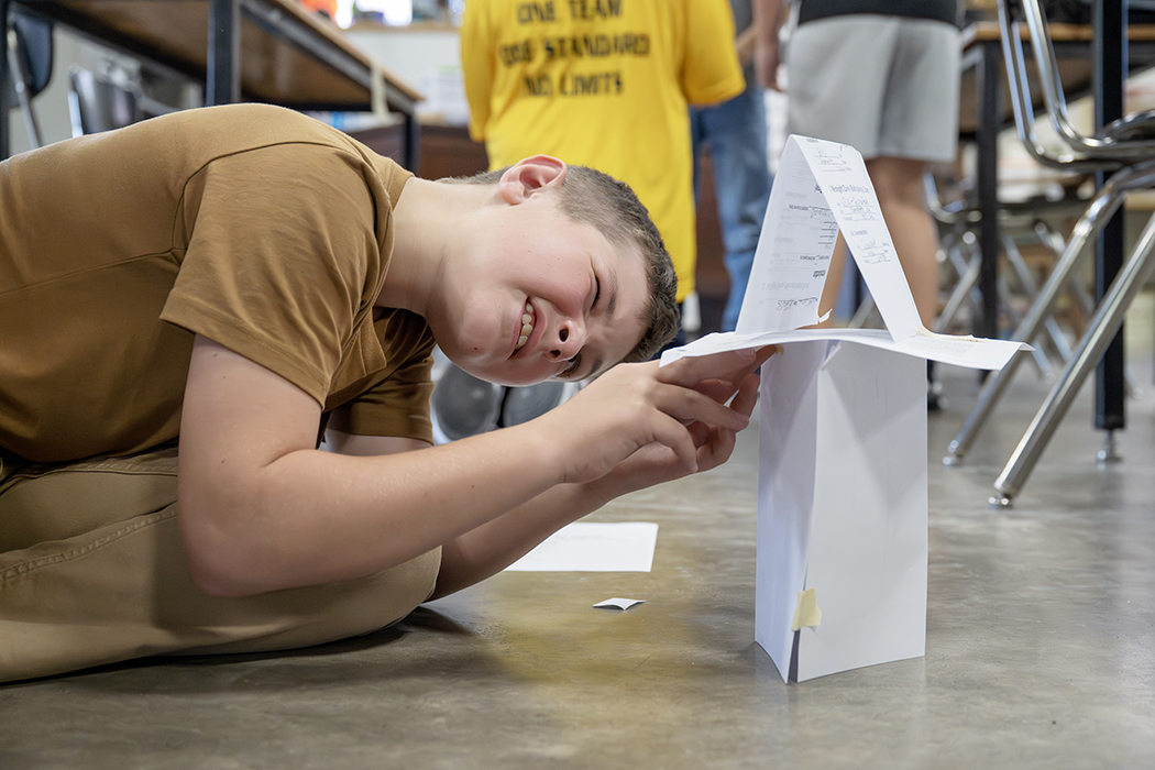 A student builds a tower out of paper.